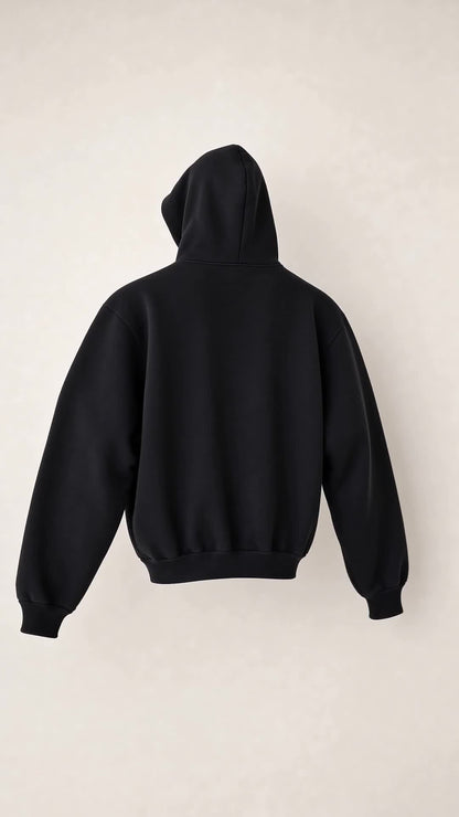 Back view of the SNDGRS STILL. Volume 001 black heavyweight pullover on an off-white background.