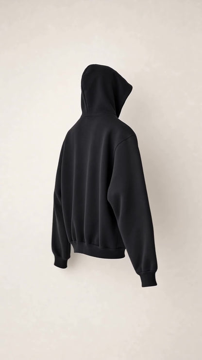 Right-side profile of the SNDGRS STILL. Volume 001 black heavyweight pullover on an off-white background.